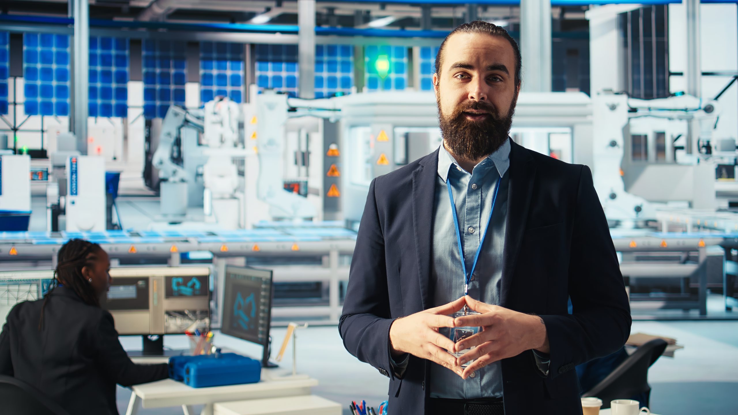 Man in photovoltaics factory films promotional video about sustainable energy production. Solar panels manufacturing factory specialist explains solar cells production process to audience, camera A