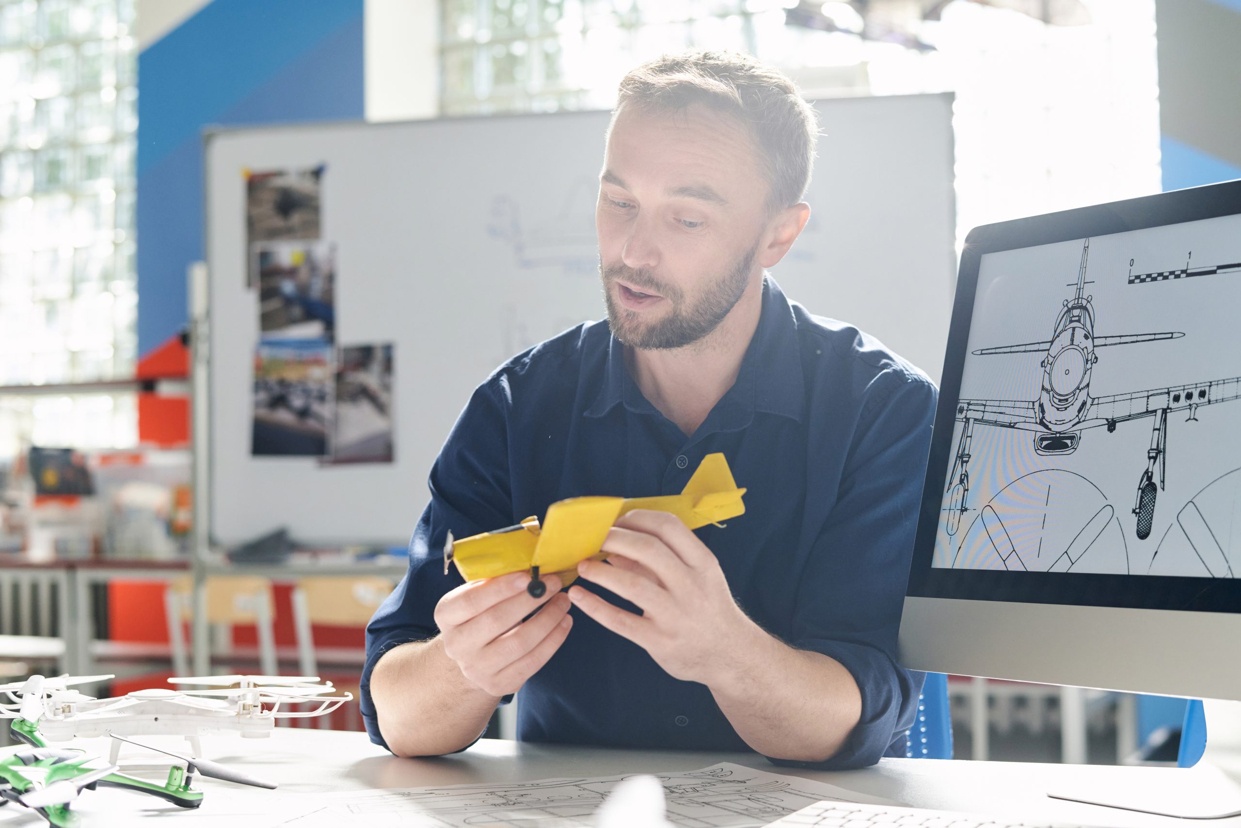 Teacher holding toy plane when talking about history of aviation